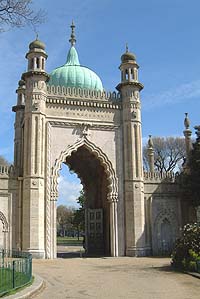 Shows a photograph of a large, ornate stone gateway with an onion-shaped green roof.